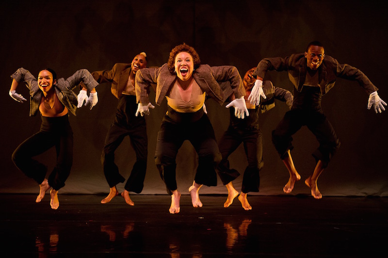 Mr. Tol E. Rance dancers hover in the air looking gleefully. They each wear white gloves